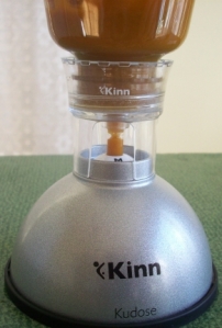 The Kinn Kudose pill concealer with a pill case in it, the bottle on top, and sweet potato/turkey baby food being put inside.